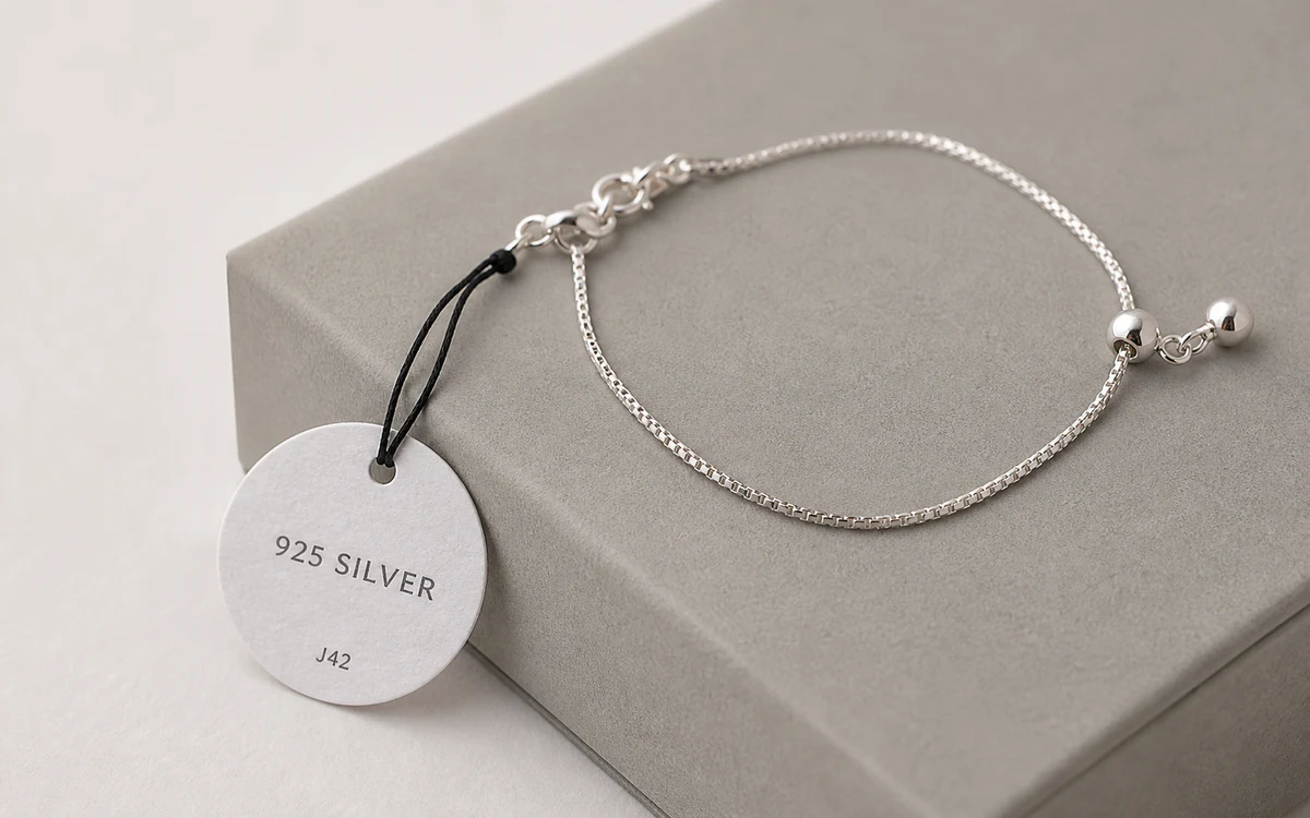 Circular 925 silver jewellery tag attached to a bracelet